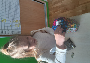 Dziewczynka wrzuca pieniądze do puszki