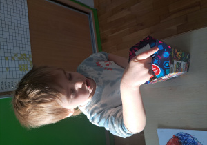 Chłopiec wrzuca pieniądze do puszki