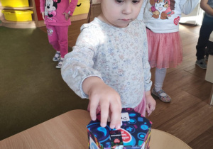 Dziewczynka wrzuca pieniądze do puszki