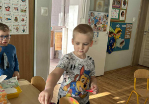 Chłopiec wrzuca pieniądze do puszki