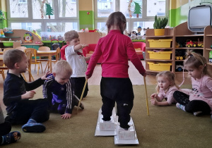 Dziewczynka na kartonowych nartach