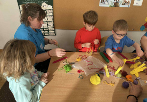 Dzieci uczą się przeplatać nitkę