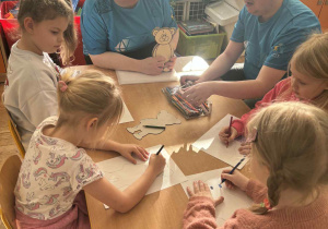 Dzieci odrysowują szablon misia