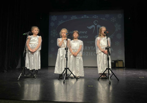 Dziewczynki podczas występu stoją przy mikrofonach