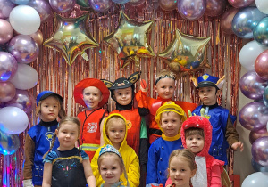 Dzieci z grupy I pozują przy ściance karnawałowej do zdjęć