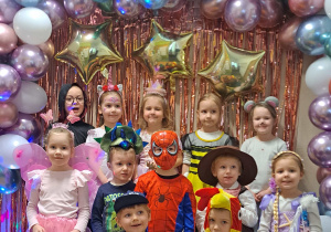 Dzieci z grupy I pozują przy ściance karnawałowej do zdjęć