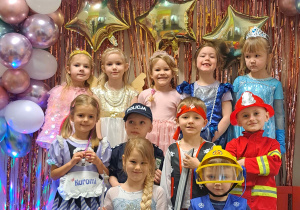 Dzieci z grupy II pozują przy ściance karnawałowej do zdjęć