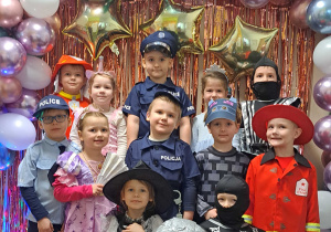 Dzieci z grupy I pozują przy ściance karnawałowej do zdjęć