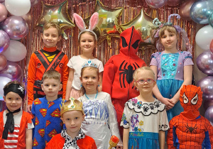 Dzieci z grupy III pozują przy ściance karnawałowej do zdjęć