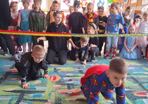 Dzieci z grupy III i IV podczas zabawy w przechodzenie pod liną