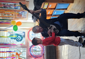 Chłopiec próbuje grać na gitarze