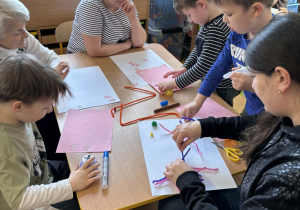 Rodzice z dziećmi podczas wykonywania herbów