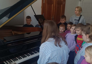 Dzieci słuchają dźwięków pianina