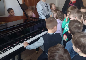 Chłopiec próbuje grać na pianinie