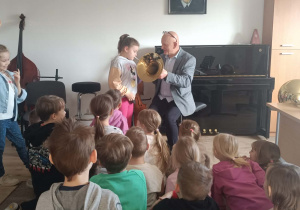 Dziewczynka próbuje zagrać na instrumencie dętym