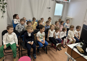 Dzieci słuchają bajki czytanej przez panią bibliotekarkę