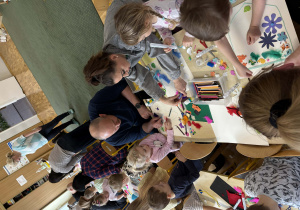 Rodzice z dziećmi podczas wykonywania herbu