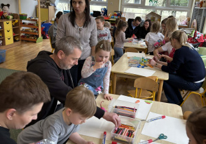 Rodzice z dziećmi podczas wykonywania herbu