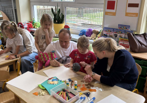 Rodzice z dziećmi podczas wykonywania herbu