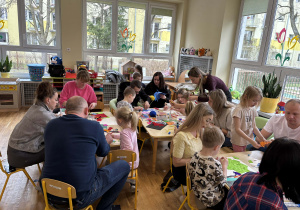 Rodzice z dziećmi podczas wykonywania herbu