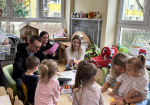 Rodzice z dziećmi podczas wykonywania herbu