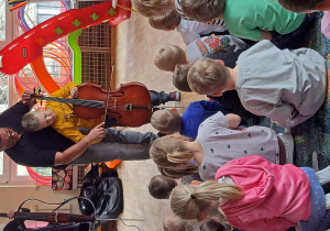 Chłopiec próbuje zagrać na wiolonczeli