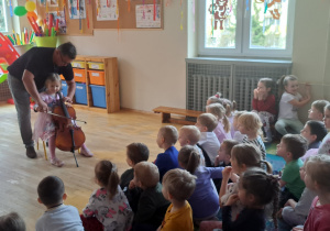 Dziewczynka próbuje zagrać na wiolonczeli
