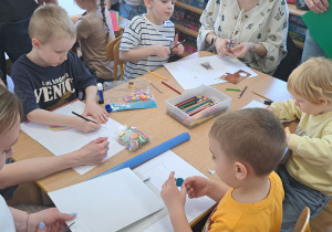 Dzieci z rodzicami podczas wykonywania herbów