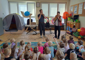 Dzieci słuchają muzyki granej na peruwiańskich instrumentach