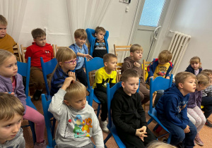 Dzieci podczas czytania książki przez panią bibliotekarkę