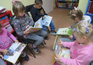 Dzieci oglądają książki w bibliotece