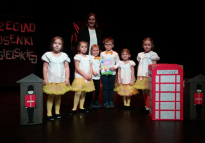 Piątka dzieci z grupy V z Panią stoją na scenie