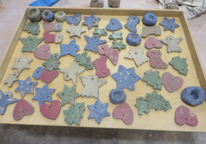 Ozdoby ceramiczne wykonane przez dzieci w kształcie gwiazdki, choinek i aniołków