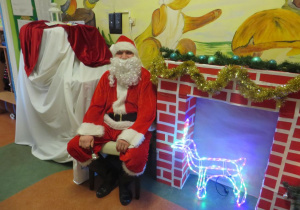 Święty Mikołaj siedzi w holu przedszkola