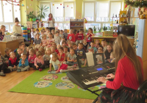 Przedszkolaki słuchają kolędy wykonanej na instrumencie klawiszowym
