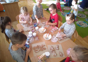 Dzieci ozdabiają pierniki lukrem i cukiereczkami