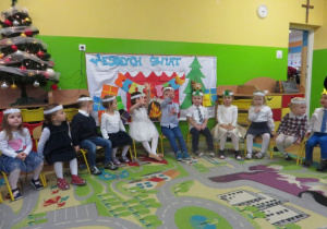 Dzieci z grupy I siedzą podczas występu świątecznego