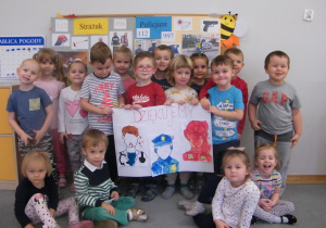 Dzieci z grupy II prezentują swoją pracę pomalowaną farbami, na której są przedstawiciele służb ratunkowych