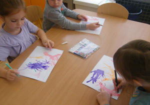 Troje dzieci rysuje emocjom buzie