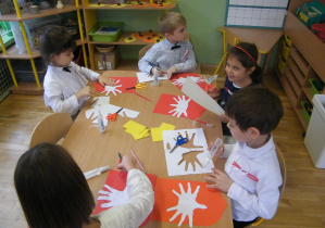 Dzieci starsze z grupy IV wykonują godło Polski z odrysowanych rąk