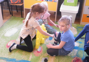 Dziewczynki układają wieżę z żółtych kubków