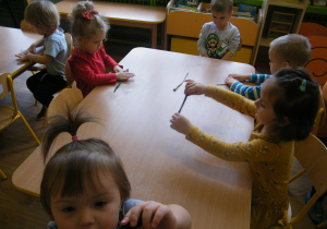 Dzieci robią wałeczki z plasteliny