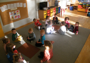 Dzieci z grupy II siedzą w dwóch kołach przy brązowych kartonach