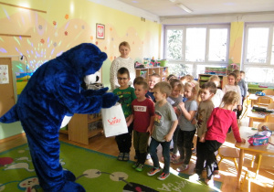 Duży Niebieski Pluszowy Miś częstuje dzieci z grupy III cukierkami