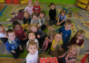 Dzieci z grupy I czekają na otworzenie paczki od Mikołaja