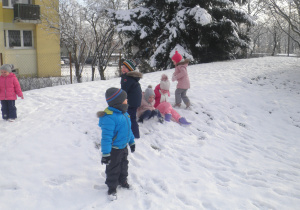 Dzieci bawią się na zaśnieżonej górce
