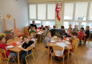 Dzieci z grupy V siedzą przy stołach