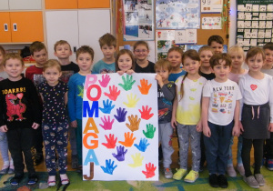Dzieci z grupy V pokazują swój plakat dla wolontariuszy