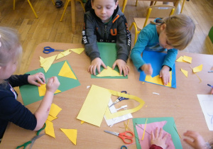 Dzieci z grupy III składają kwadrat z mniejszych figur geometrycznych