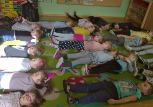 Przedszkolaki z grupy III leżą na dywanie i słuchają kołysanki